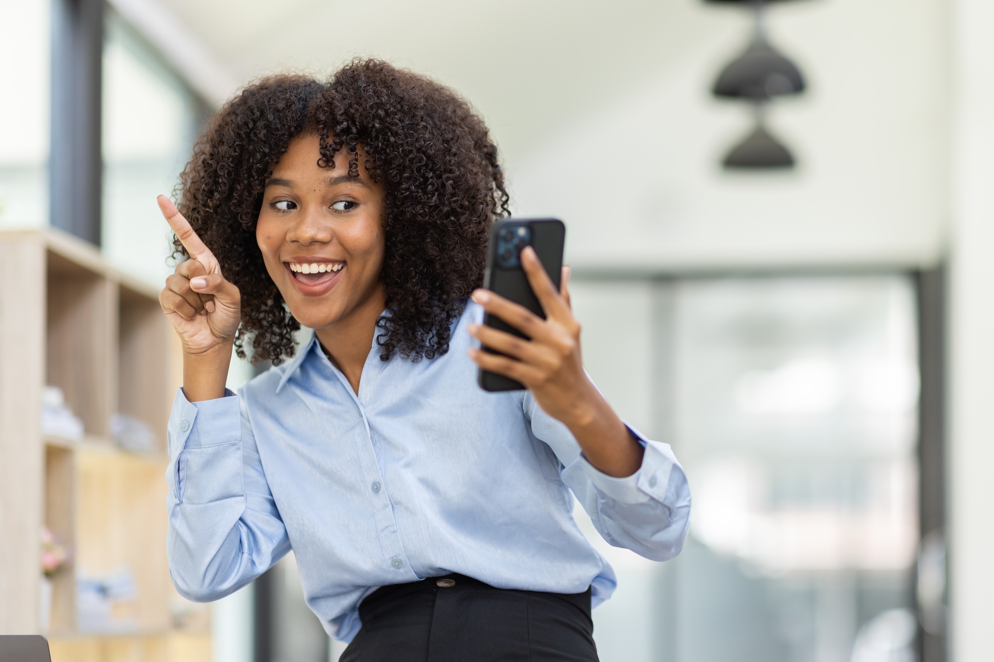 Beautiful asian african american business woman sitting on phone at office desk,