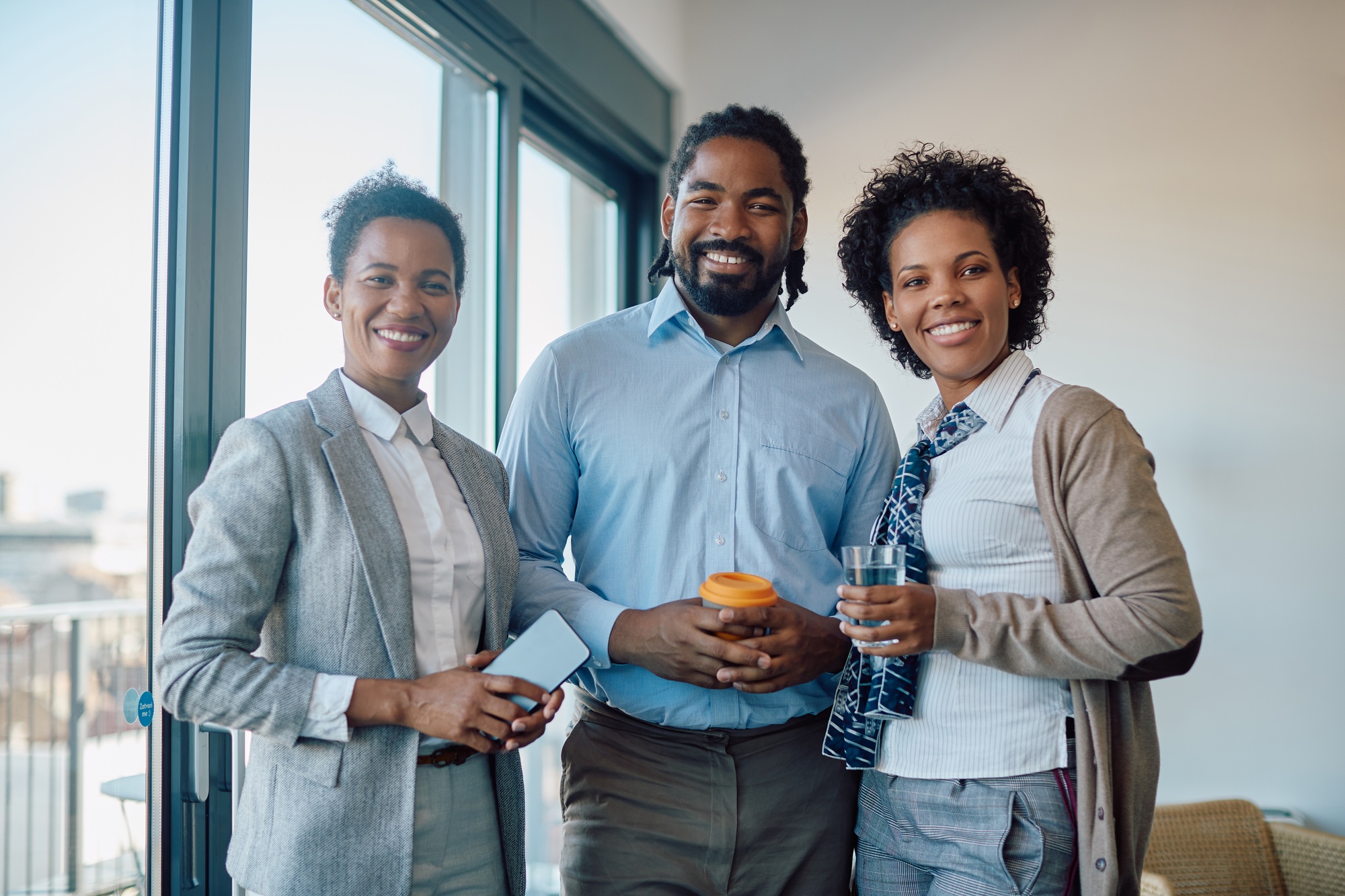 Portrait of happy African American business colleagues in the office looking at camera.